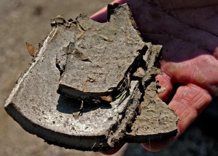 BAY ST. LOUIS, MS -- SEP 12, 2005: Gene Herring, Environmental Engineer with the Mississippi Department of Health holds a clay sample washed to shore from the 